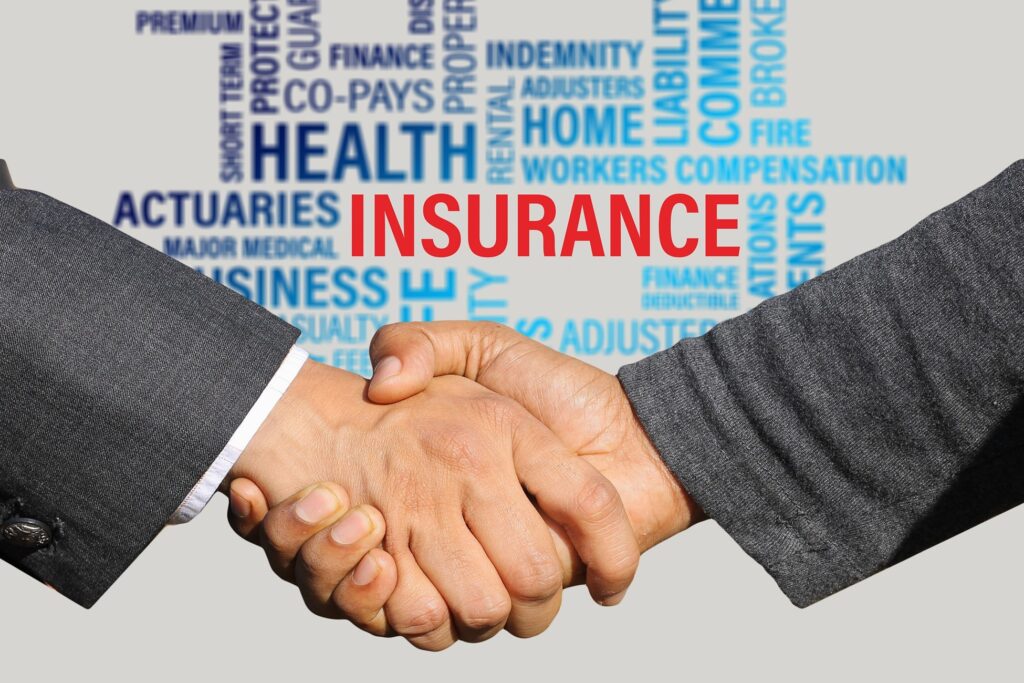 The image shows two people shaking hands with the word 'insurance' in the middle surrounded by related words such as 'health', 'home', 'workers compensation', and 'liability'.