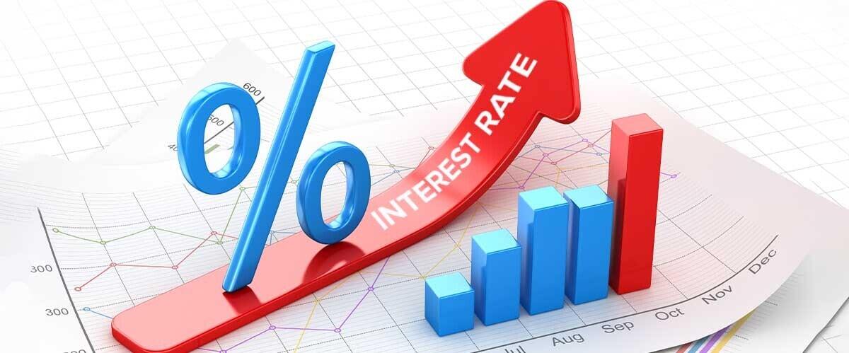 A red arrow pointing upwards with the text 'INTEREST RATE' written on it, positioned over a blue percent symbol and a graph with blue bars increasing in size.