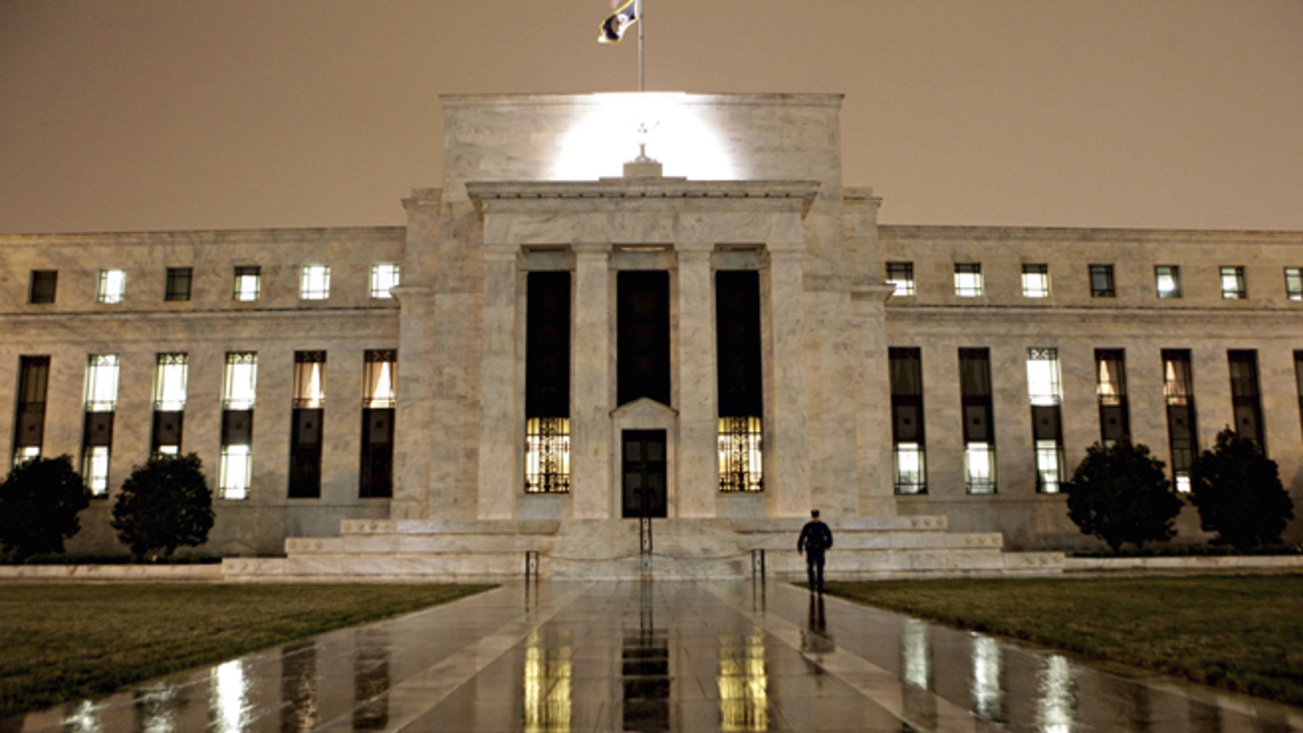 The exterior of the Federal Reserve building in Washington, D.C., is shown at night.